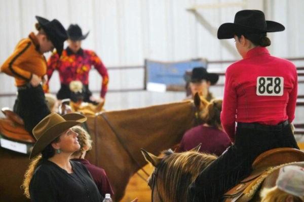 A group of people in western hats riding horses